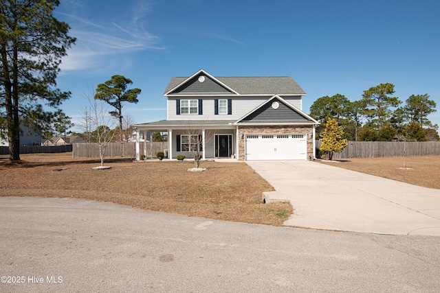 traditional-style house featuring a garage, concrete driveway, a porch, and fence