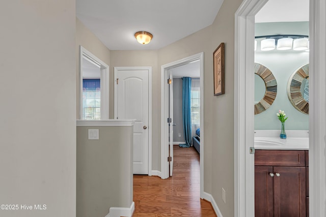 corridor featuring wood finished floors and baseboards