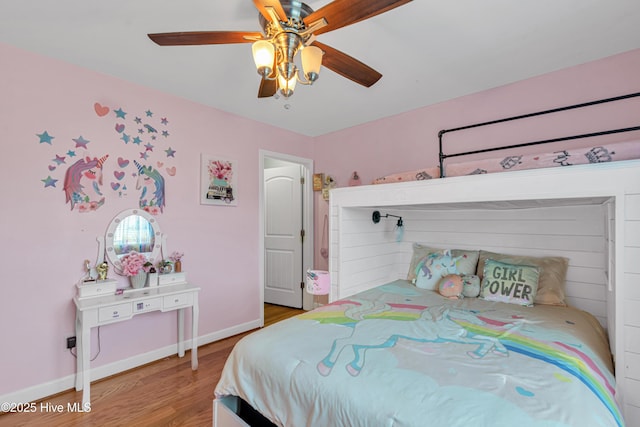 bedroom featuring light wood finished floors, baseboards, and a ceiling fan