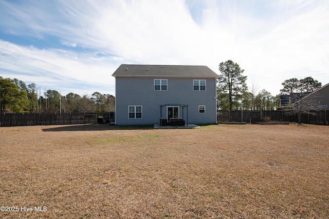 back of property featuring a fenced backyard and a lawn