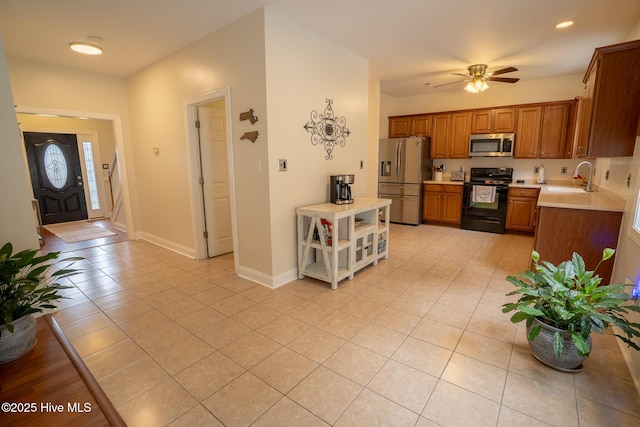 kitchen featuring stainless steel appliances, light countertops, a sink, and light tile patterned flooring