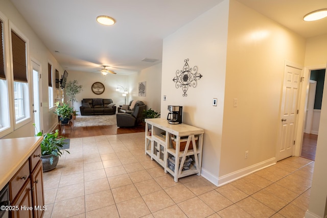 hallway featuring light tile patterned flooring and baseboards