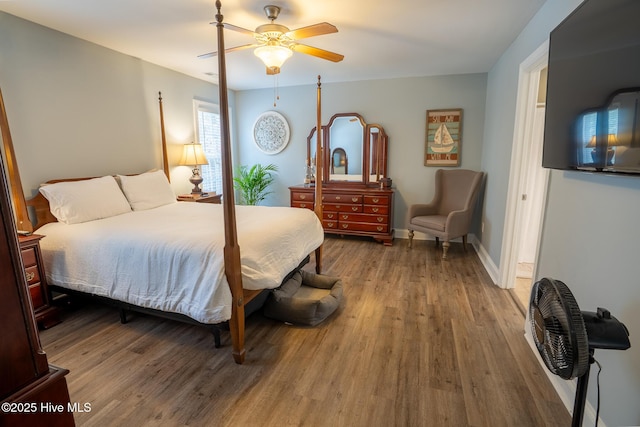 bedroom featuring ceiling fan, baseboards, and wood finished floors