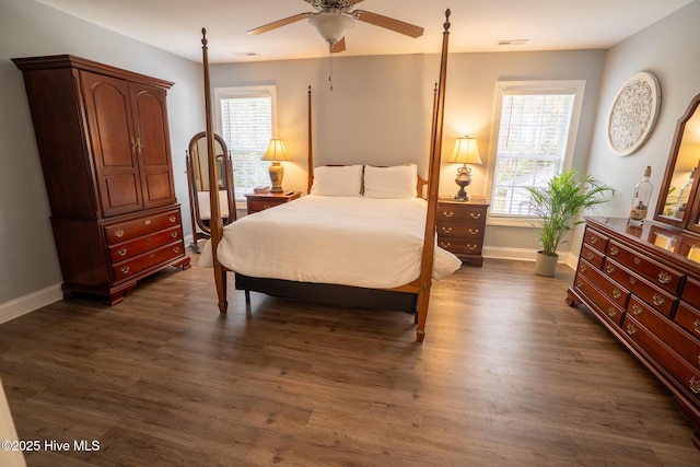 bedroom featuring baseboards, multiple windows, visible vents, and dark wood finished floors