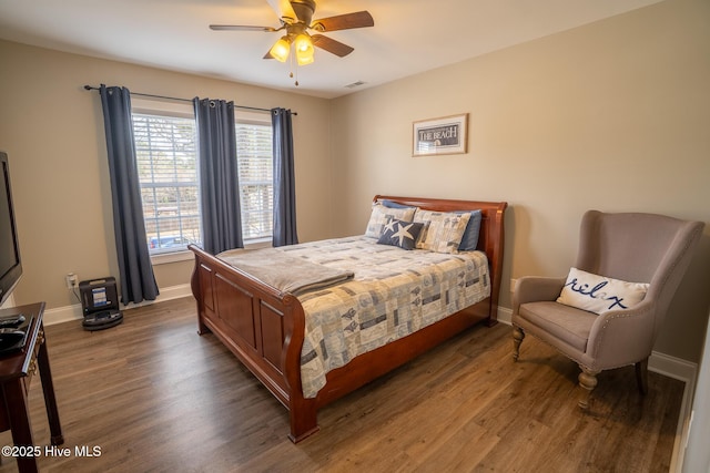 bedroom with visible vents, wood finished floors, a ceiling fan, and baseboards