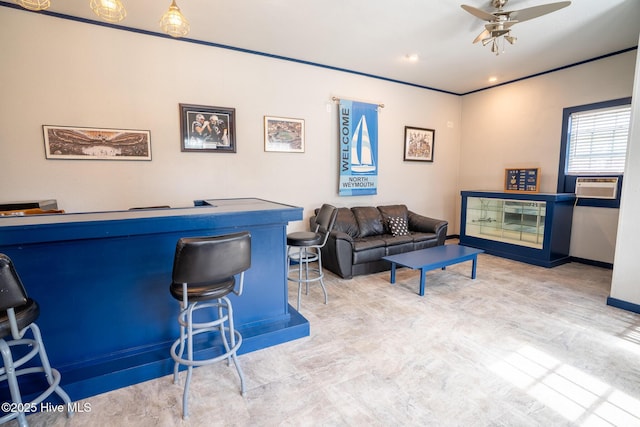 bar featuring cooling unit, baseboards, ceiling fan, and a bar