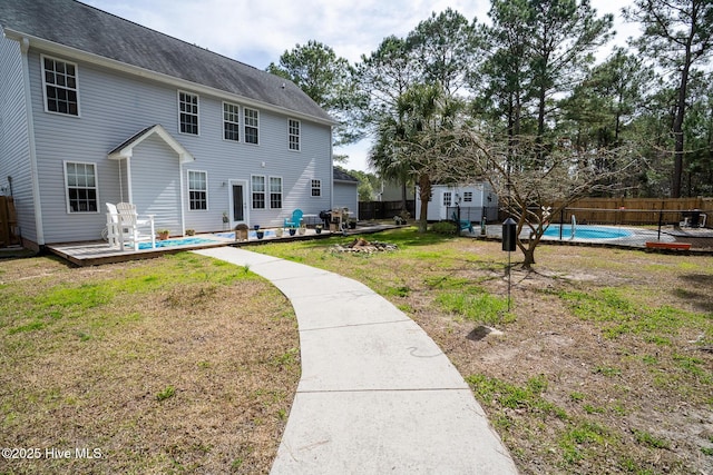 back of house featuring a fenced in pool, a yard, a deck, and fence