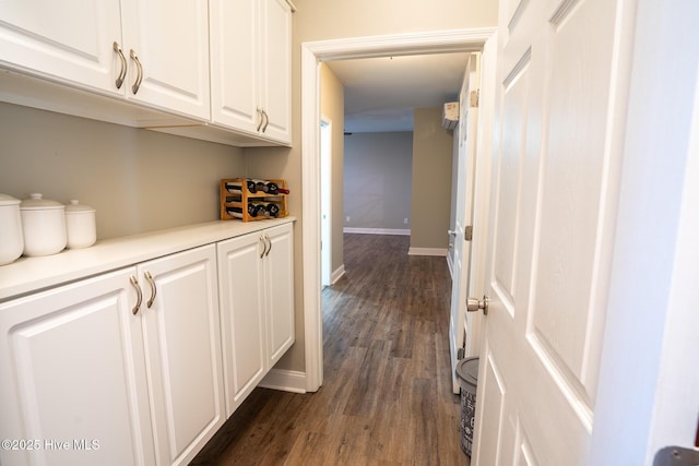 hallway with baseboards and dark wood-style flooring