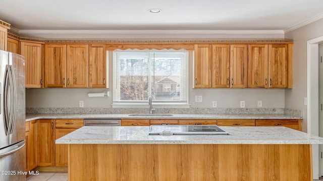 kitchen with electric cooktop, a sink, ornamental molding, freestanding refrigerator, and light stone countertops