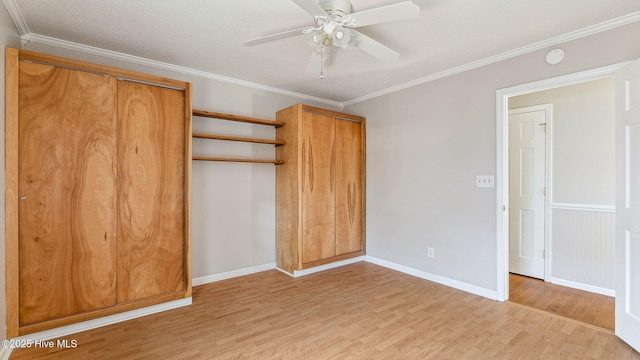 unfurnished bedroom featuring light wood finished floors, a ceiling fan, baseboards, and crown molding