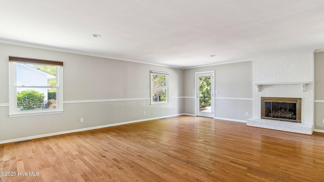 unfurnished living room featuring a healthy amount of sunlight, visible vents, and light wood finished floors