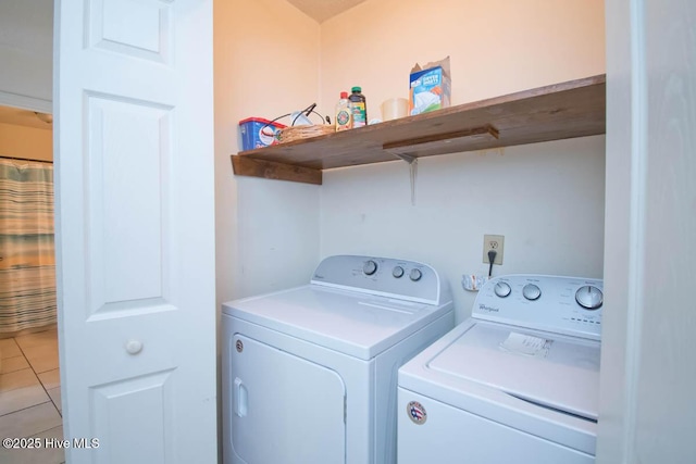 clothes washing area with light tile patterned flooring, laundry area, and washer and clothes dryer