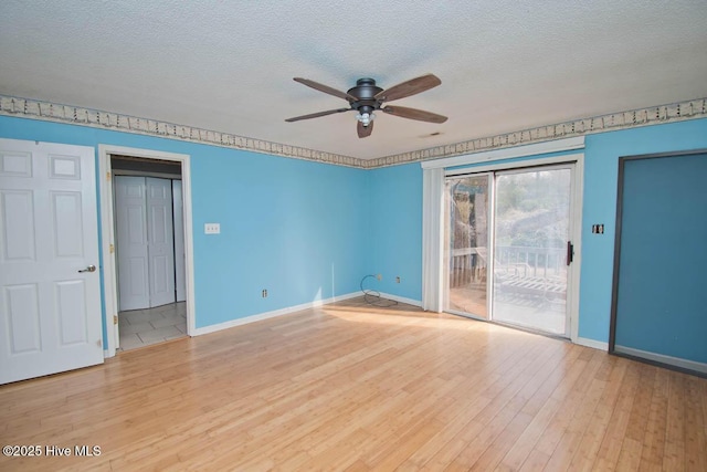 spare room featuring wood finished floors, baseboards, and a textured ceiling