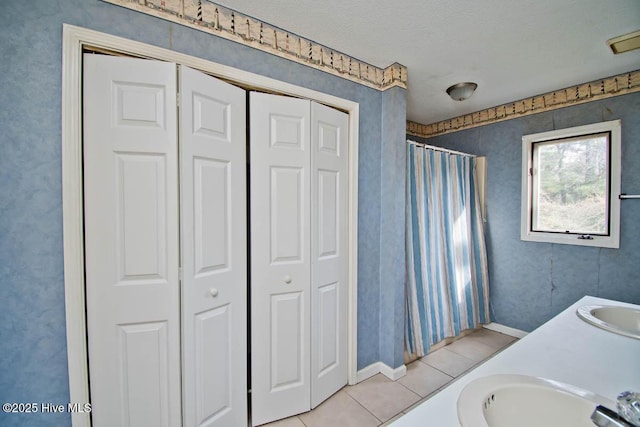 full bathroom featuring tile patterned floors, a closet, and a sink