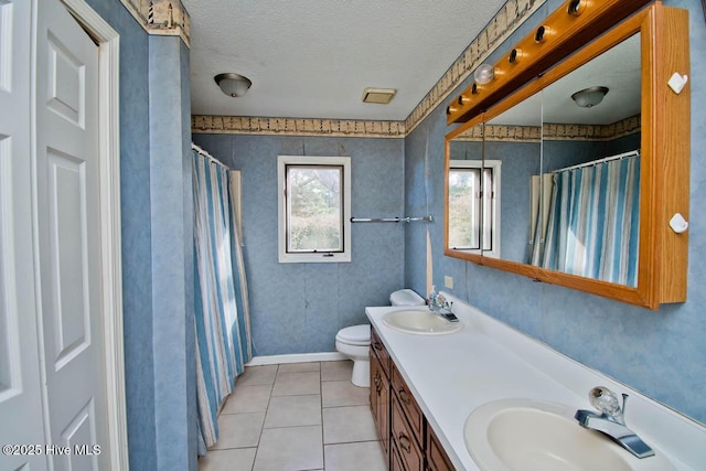 full bath with tile patterned flooring, toilet, a textured ceiling, and a sink