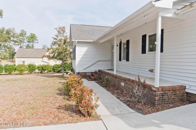 view of home's exterior with crawl space and a shingled roof