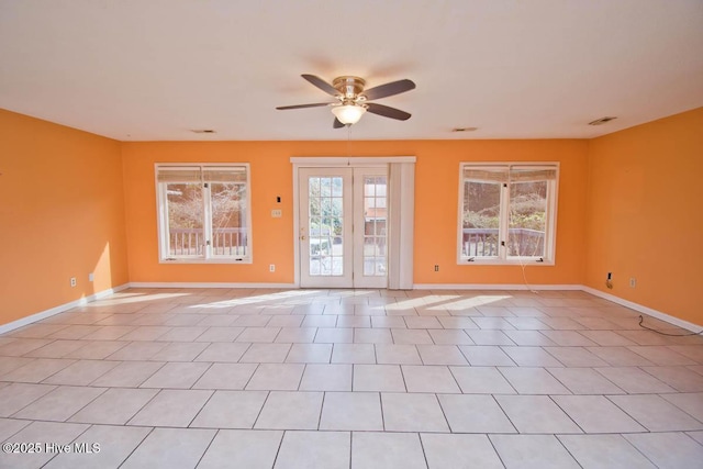 unfurnished room featuring visible vents, a ceiling fan, and baseboards