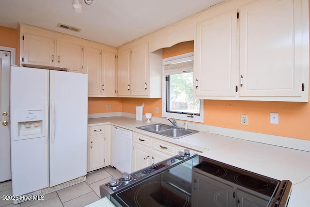 kitchen with white appliances, light tile patterned floors, light countertops, and a sink