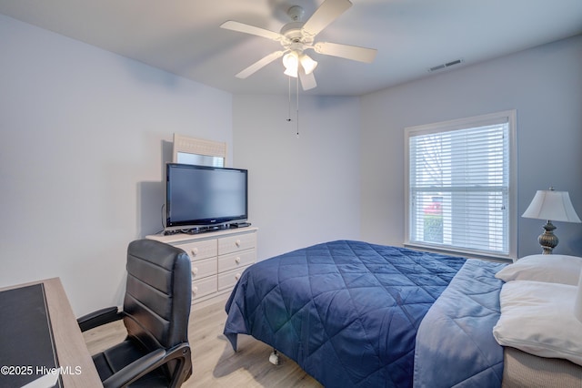 bedroom with light wood-style flooring, visible vents, and ceiling fan