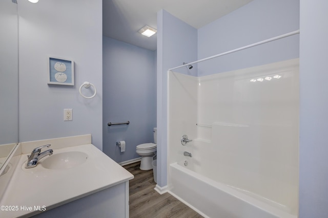 bathroom featuring toilet, wood finished floors, vanity, bathing tub / shower combination, and baseboards