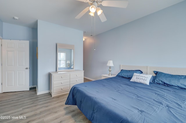 bedroom featuring light wood-style floors, ceiling fan, and baseboards