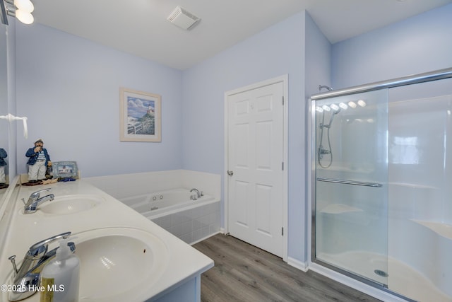 full bathroom featuring visible vents, a sink, a shower stall, wood finished floors, and a bath