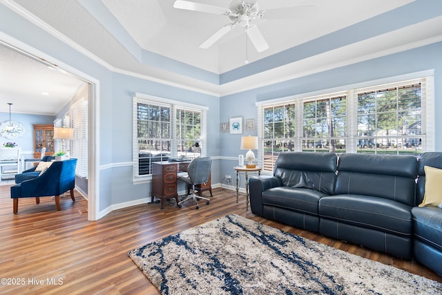 living room featuring crown molding, a raised ceiling, ceiling fan, wood finished floors, and baseboards