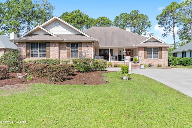 ranch-style house with brick siding, a chimney, a porch, driveway, and a front lawn