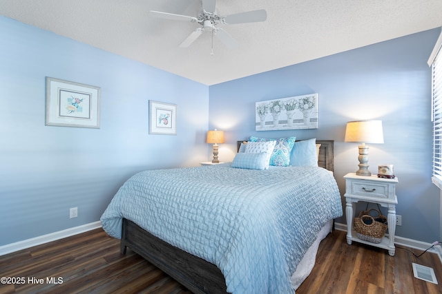 bedroom with a ceiling fan, visible vents, baseboards, and wood finished floors