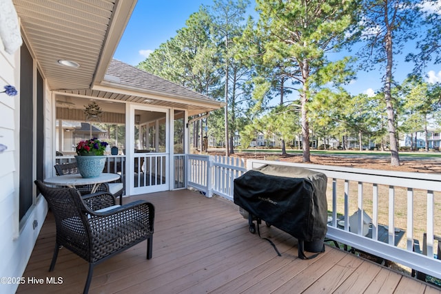 wooden deck featuring area for grilling and a sunroom