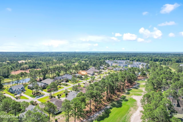 drone / aerial view featuring a wooded view and a residential view