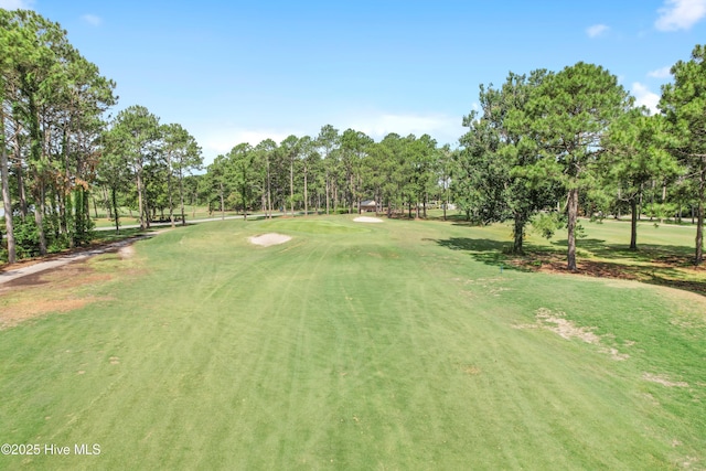 view of home's community featuring view of golf course and a yard