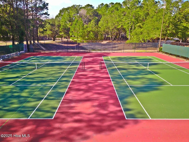 view of tennis court featuring community basketball court and fence