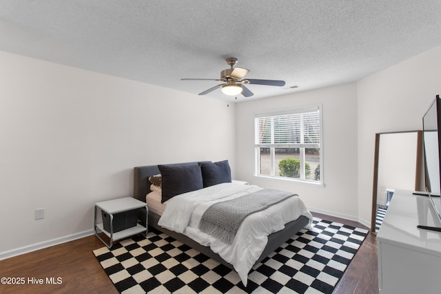 bedroom featuring a textured ceiling, dark wood-style flooring, and baseboards