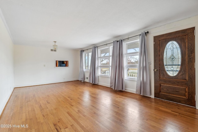 foyer with crown molding, light wood-style floors, and baseboards