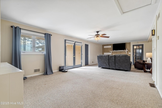 living area with visible vents, baseboards, attic access, and carpet flooring