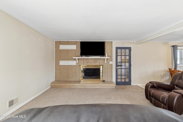 carpeted living area featuring visible vents, a brick fireplace, crown molding, and baseboards