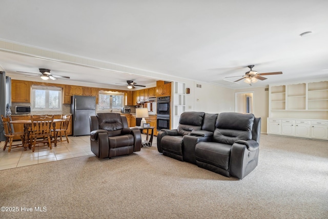 living area featuring light tile patterned flooring, visible vents, and light colored carpet