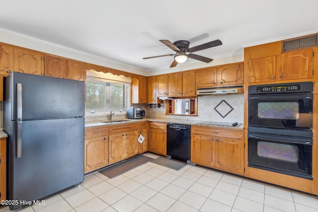 kitchen featuring under cabinet range hood, visible vents, black appliances, and brown cabinetry