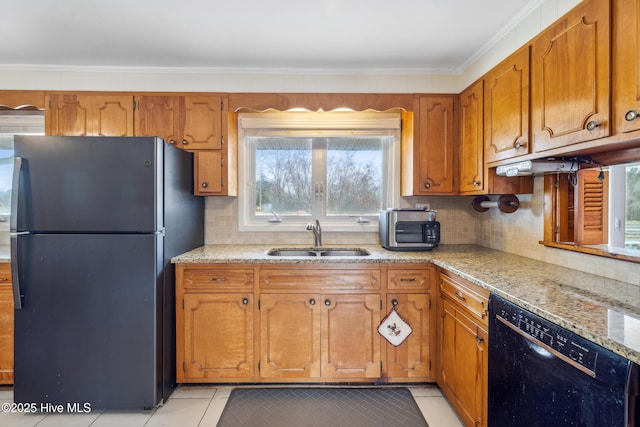 kitchen featuring a sink, brown cabinets, black appliances, and light tile patterned flooring