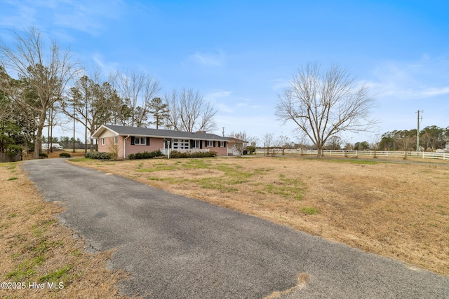 view of front of home featuring brick siding, a front yard, and fence