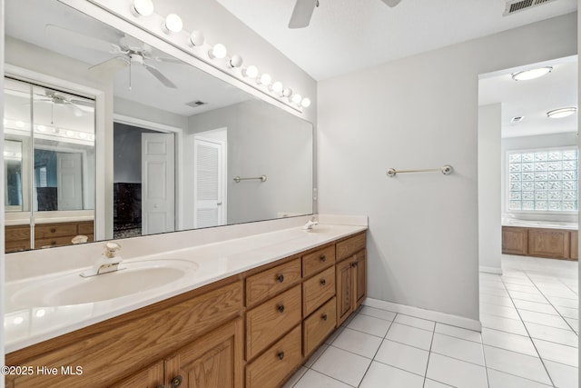 full bath with tile patterned flooring, a garden tub, double vanity, a ceiling fan, and a sink