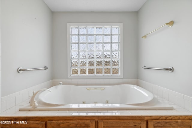 bathroom featuring plenty of natural light and a tub with jets