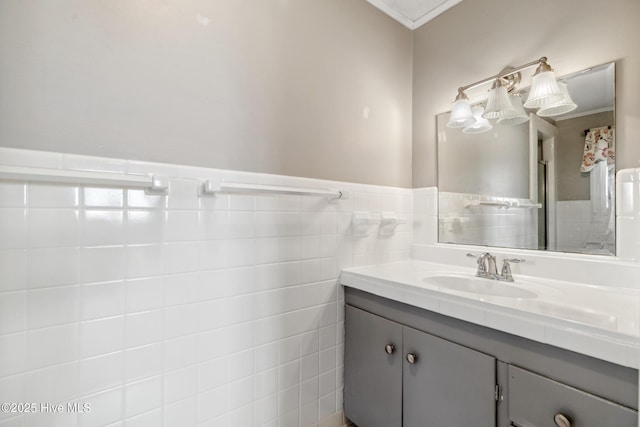 bathroom featuring wainscoting, vanity, and tile walls