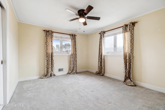 carpeted spare room featuring ceiling fan, baseboards, and ornamental molding