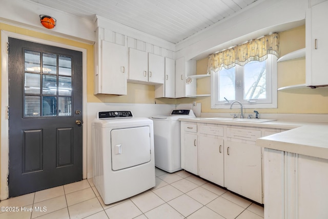 laundry room featuring washer and dryer, light tile patterned floors, cabinet space, and a sink