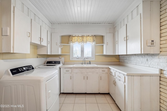 washroom featuring light tile patterned floors, wooden ceiling, cabinet space, independent washer and dryer, and a sink