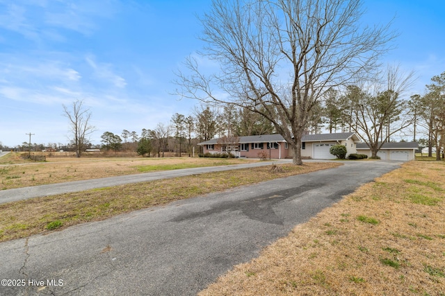 view of front facade featuring a front yard, an attached garage, and driveway