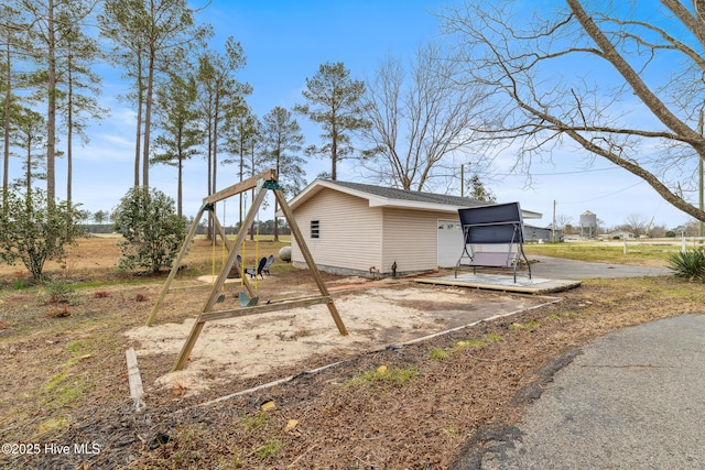 exterior space with an outbuilding, a playground, and roof with shingles