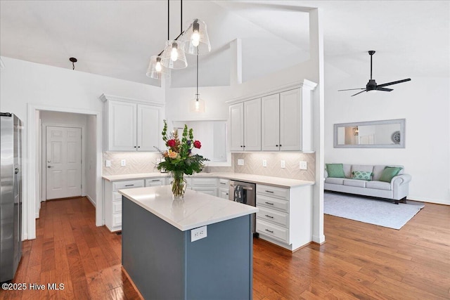 kitchen with decorative backsplash, a kitchen island, dark wood-style flooring, and white cabinetry